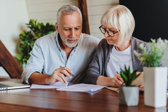 A mature couple with financial documents inside the house