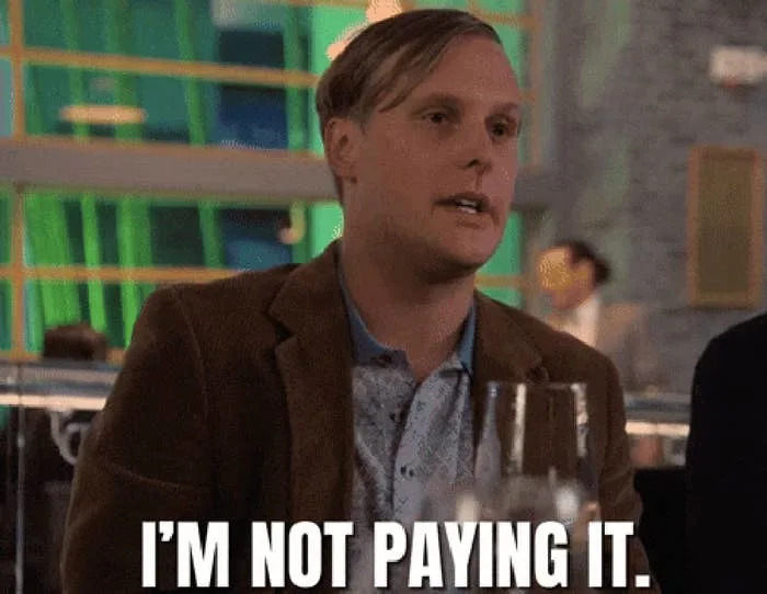 The man in the restaurant, wearing a blazer, says, "I don't pay it."
