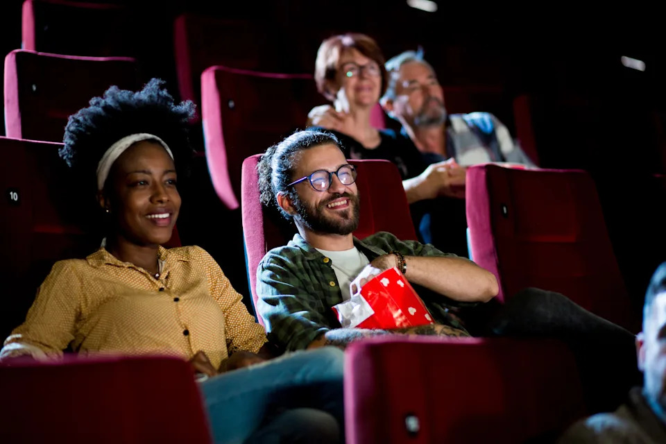 People sitting in the cinema, smiling and enjoying the movie