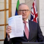Men in suits speak at a press conference