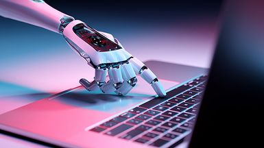 A robot hand presses a laptop button.