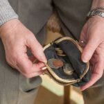 The pensioner's hands checking the loose change in the bag