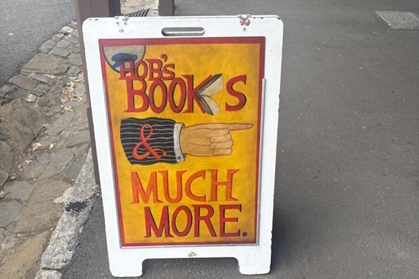 A framed sign that reads 'Bob's books, and more' 