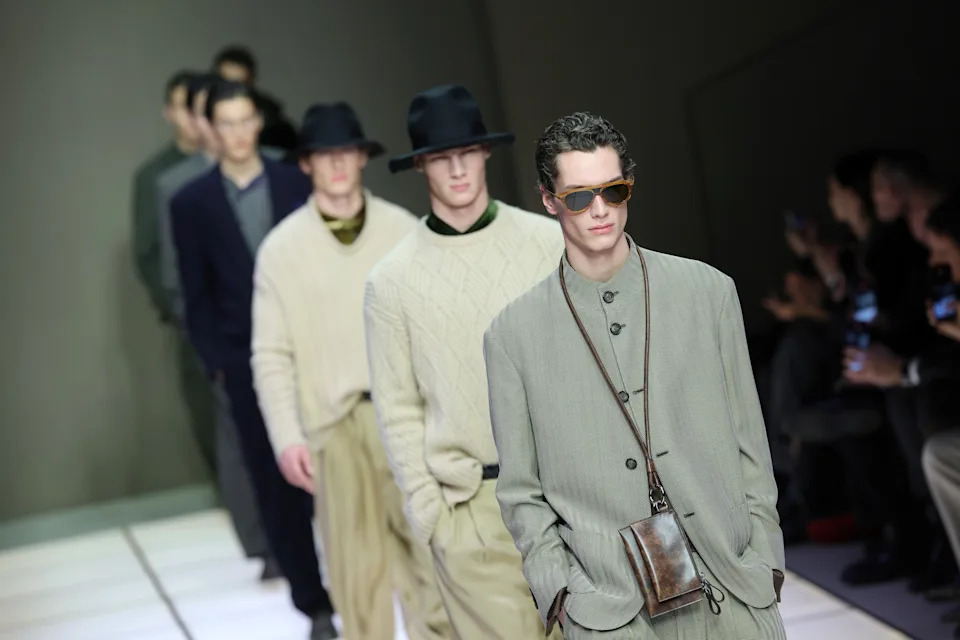 Models walk the fashion show wearing vintage inspired suits, sweaters and hats. The main example is sports sunglasses and a small leather bag
